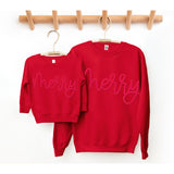 Two red sweatshirts with 'merry' text on hangers against a white background